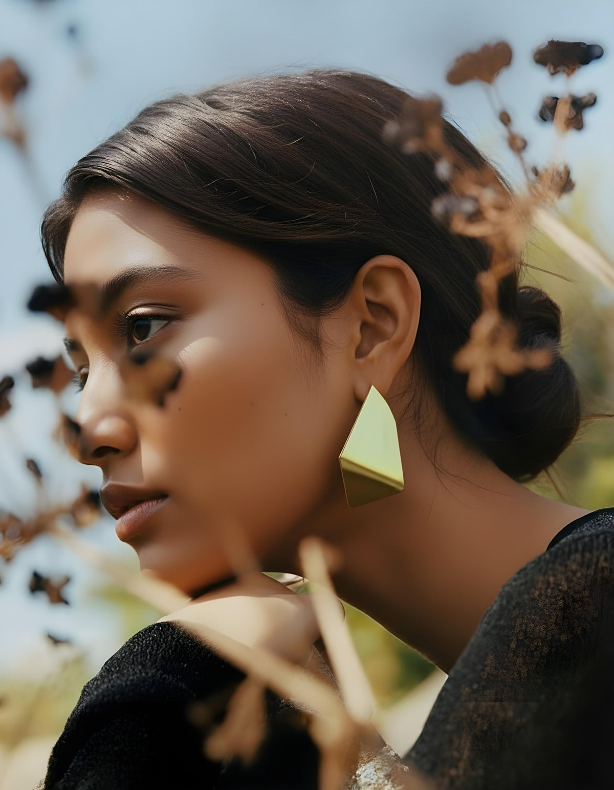 Model wearing gold geometric Aurum Facet Earrings