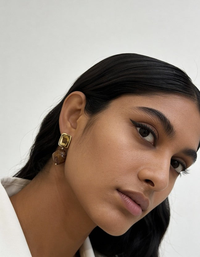 Model wearing grey marbled Stone Drop Earrings with gold-toned square studs